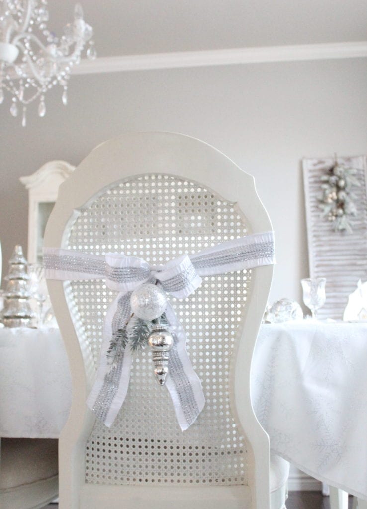 adding glam to christmas decor winter wonderland tablescape bows on chairs