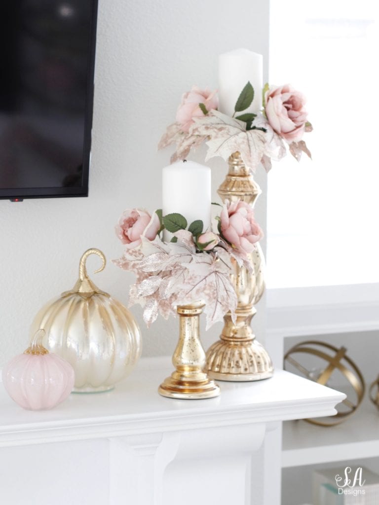 blush pink glass pumpkins, homegoods pumpkins, blush glam fall mantel decor, eucalyptus blush pink mauve roses swag, crystorama calypso chandelier, brass gold crystal chandelier, television over mantel mantle, tv above fireplace, mercury glass gold silver candle holders candle rings candle wreaths, fall glam candle rings, blush candle rings, white built-ins, white interiors, white hearth marble tile