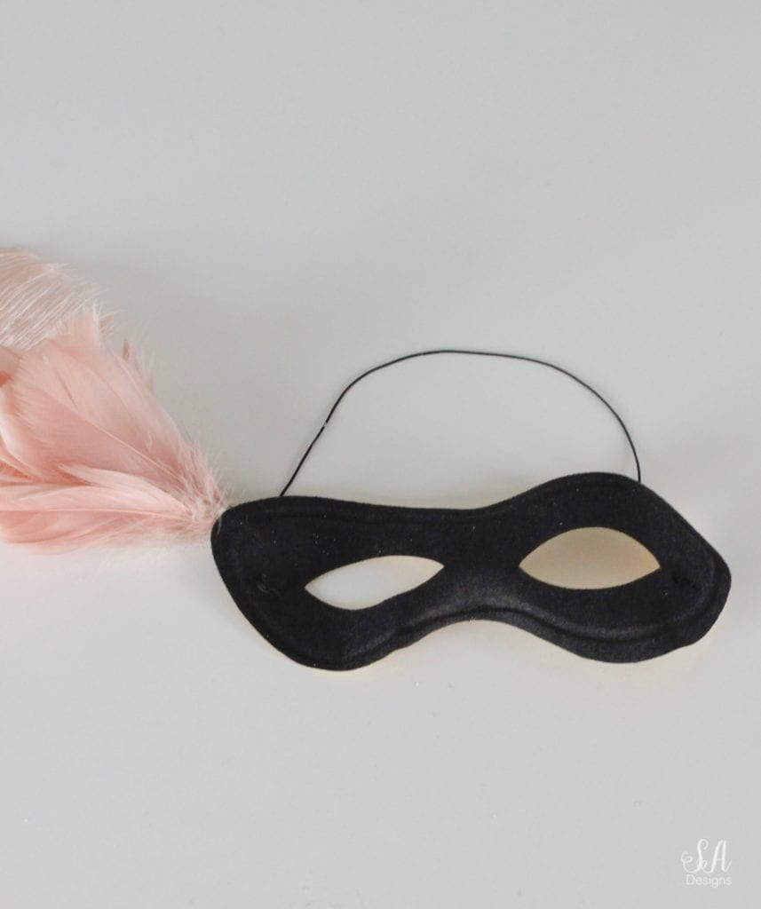 black eye mask, halloween mask, costume mask, blush pink feather joanns, swarovski crystals, diy halloween mask, diy halloween craft, diy mask, glam halloween decor costume, chic halloween decor, elegant halloween decor, blush pink and black masquerade mask