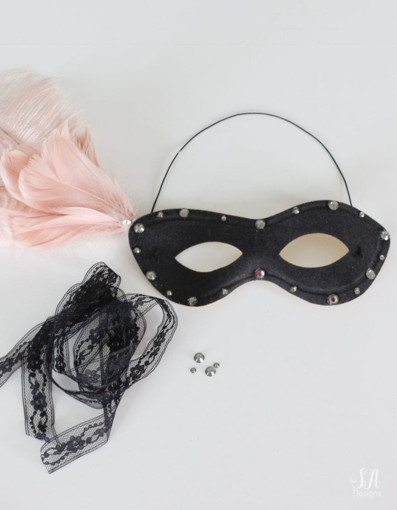 black eye mask, halloween mask, costume mask, blush pink feather joanns, swarovski crystals, diy halloween mask, diy halloween craft, diy mask, glam halloween decor costume, chic halloween decor, elegant halloween decor, blush pink and black masquerade mask