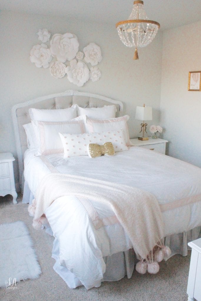 blush bedroom, blush and gold, blush gold grey, modern vintage style, modern vintage bedroom, modern vintage home decor, paper flowers on wall, french provincial furniture nightstands, gold hardware, pottery barn teen pottery barn kids monique lhuillier ethereal sateen duvet shams bedding, pbteen, sparkly crystal chandelier, pbkids chandelier, blush pink satin windows curtains window treatments, vintage gold bow mirror, kate spade ellery ivory bow lamps gold finish, nordstrom at home blush pink pom pom throw blanket, restoration hardware children and baby colette bed, grey tufted modern vintage headboard, white vanity, faux fur vanity stool, girls vanity, girls bedroom ideas, tween teen girls bedroom