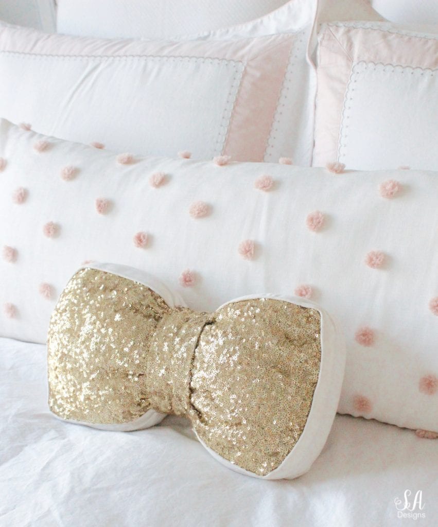 emily & meritt gold sequin bow pillow, blush bedroom, blush and gold, blush gold grey, modern vintage style, modern vintage bedroom, modern vintage home decor, paper flowers on wall, french provincial furniture nightstands, gold hardware, pottery barn teen pottery barn kids monique lhuillier ethereal sateen duvet shams bedding, pbteen, sparkly crystal chandelier, pbkids chandelier, blush pink satin windows curtains window treatments, vintage gold bow mirror, kate spade ellery ivory bow lamps gold finish, nordstrom at home blush pink pom pom throw blanket, restoration hardware children and baby colette bed, grey tufted modern vintage headboard, white vanity, faux fur vanity stool, girls vanity, girls bedroom ideas, tween teen girls bedroom