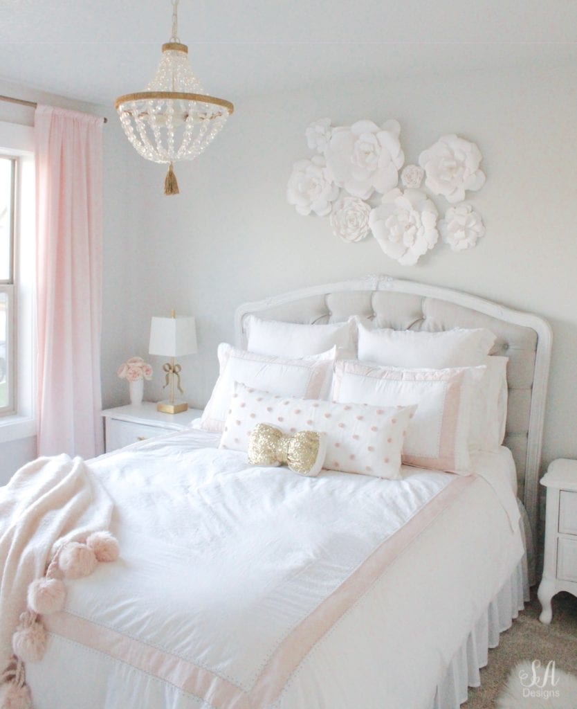 blush bedroom, blush and gold, blush gold grey, modern vintage style, modern vintage bedroom, modern vintage home decor, paper flowers on wall, french provincial furniture nightstands, gold hardware, pottery barn teen pottery barn kids monique lhuillier ethereal sateen duvet shams bedding, pbteen, sparkly crystal chandelier, pbkids chandelier, blush pink satin windows curtains window treatments, vintage gold bow mirror, kate spade ellery ivory bow lamps gold finish, nordstrom at home blush pink pom pom throw blanket, restoration hardware children and baby colette bed, grey tufted modern vintage headboard, white vanity, faux fur vanity stool, girls vanity, girls bedroom ideas, tween teen girls bedroom