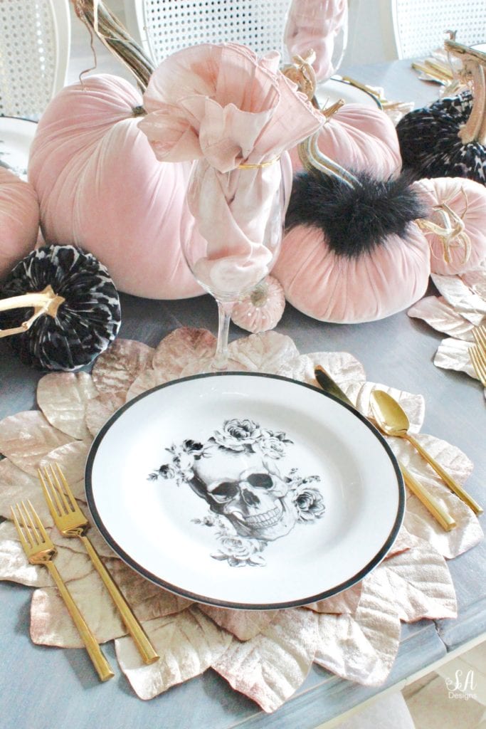 hotskwash velvet pumpkins, pink fall decor, blush fall decor, decorating with pumpkins, glam Halloween tablescape, elegant halloween decor, white halloween kitchen with pink and black, pink halloween, skull halloween plates homegoods, pier1 blush velvet placemats charger, gold rimmed clear crystal goblets, gold flatware, crystal chandelier