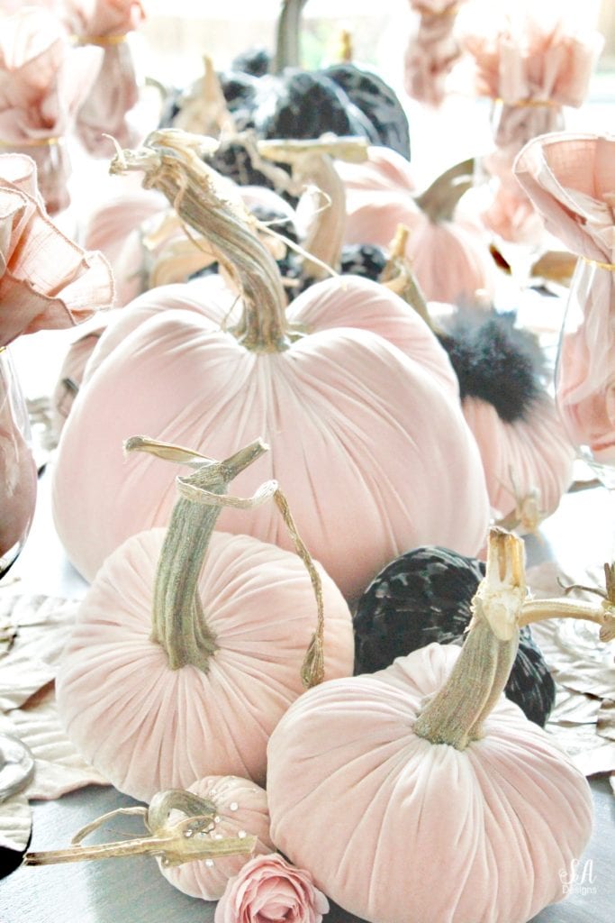 hotskwash velvet pumpkins, pink fall decor, blush fall decor, decorating with pumpkins, glam Halloween tablescape, elegant halloween decor, white halloween kitchen with pink and black, pink halloween, skull halloween plates homegoods, pier1 blush velvet placemats charger, gold rimmed clear crystal goblets, gold flatware, crystal chandelier