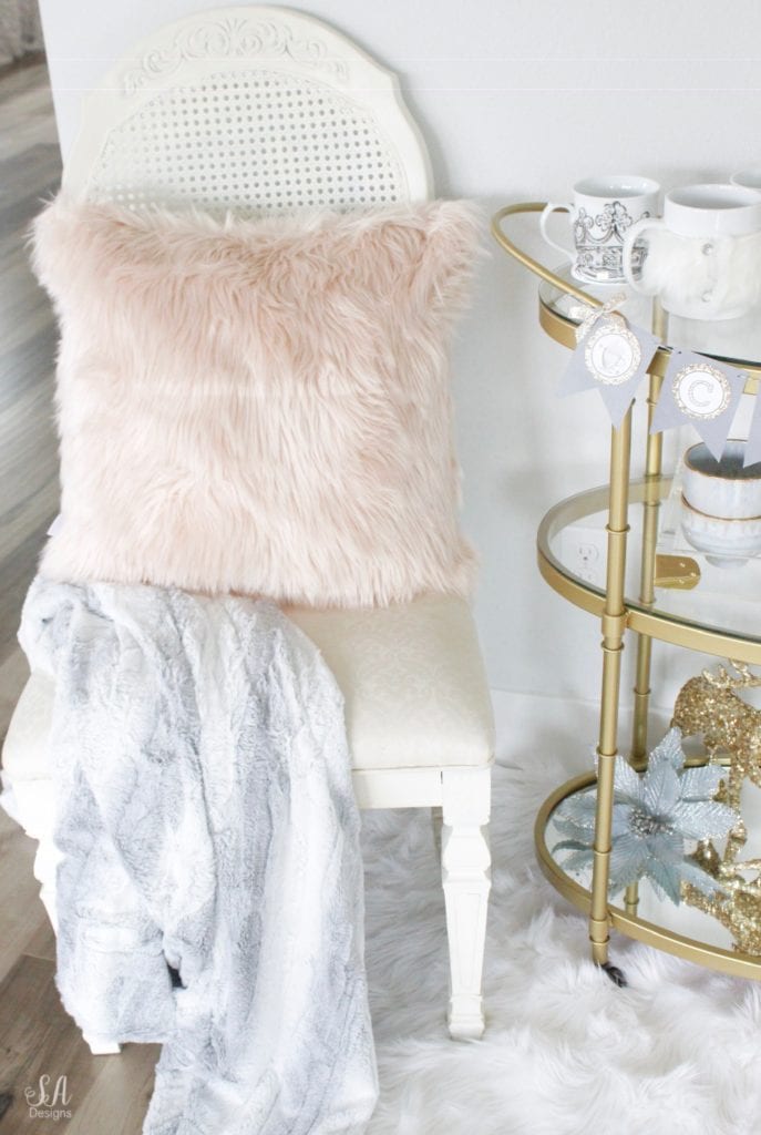 faux fur white rug, faux fur dusty blue throw blankets, blush peach pink faux fur throw pillows, vintage dining chairs white, brass gold bar cart 3 tier, diy hot cocoa station bar cart banner garland, glitter sequin white faux deer head, deer wall decoration, flocked white wreath, gold opalhouse brass wreath, blush and blue christmas, apothecary jars for hot chocolate, gold sequin glitter deer, white glitter christmas tree candles, pier one faux fur mug, acrylic brass tray, anthropologie home blue and pink bowls, white crown mugs, deer head with rhinestone crown, deer with blush satin bow