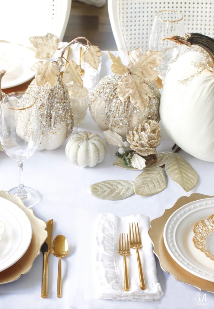 Thanksgiving table, fall table, fall tablescape, white and gold table setting place setting, elegant thanksgiving decor, chic glam thanksgiving decor, zgallerie beaded pumpkins and gourds and leaves, hotskwash velvet pumpkins, white gold champagne ivory tablescape, crystal chandelier, white kitchen design, brass pendant lights, brass hardware, vintage dining set, french inspired style, live in perigold, zgallerie beaded leaves and grape clusters