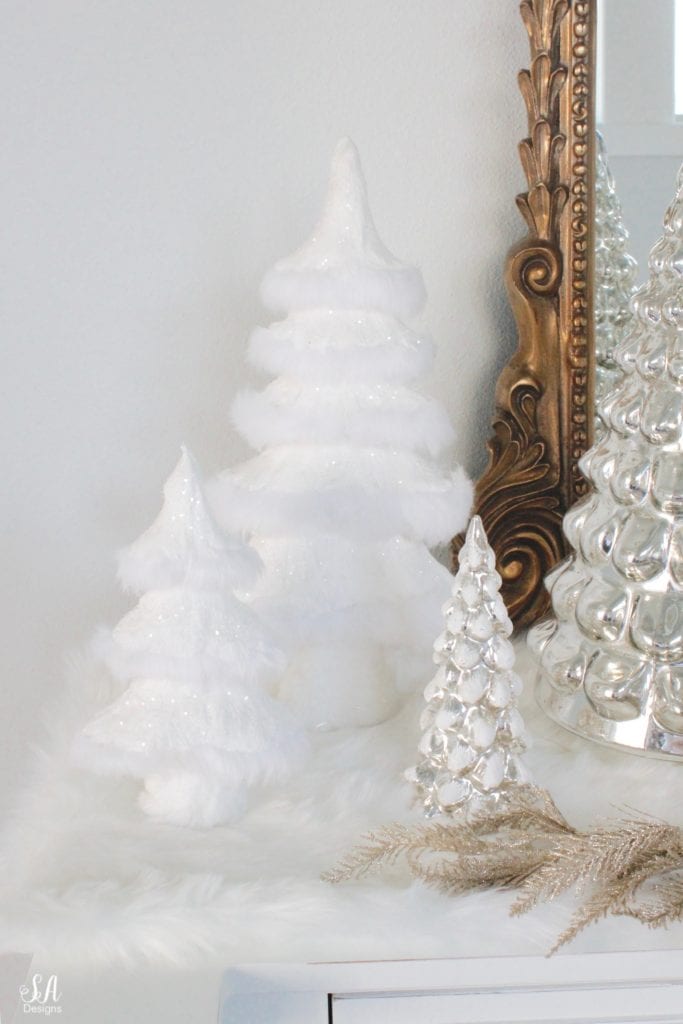 pottery barn mercury glass trees, anthropologie gleaming primrose glass mirror, elegant mixed metal decor, gold wreath, perigold dresser entry buffet table white transitional style buffet, michaels white faux fur christmas trees