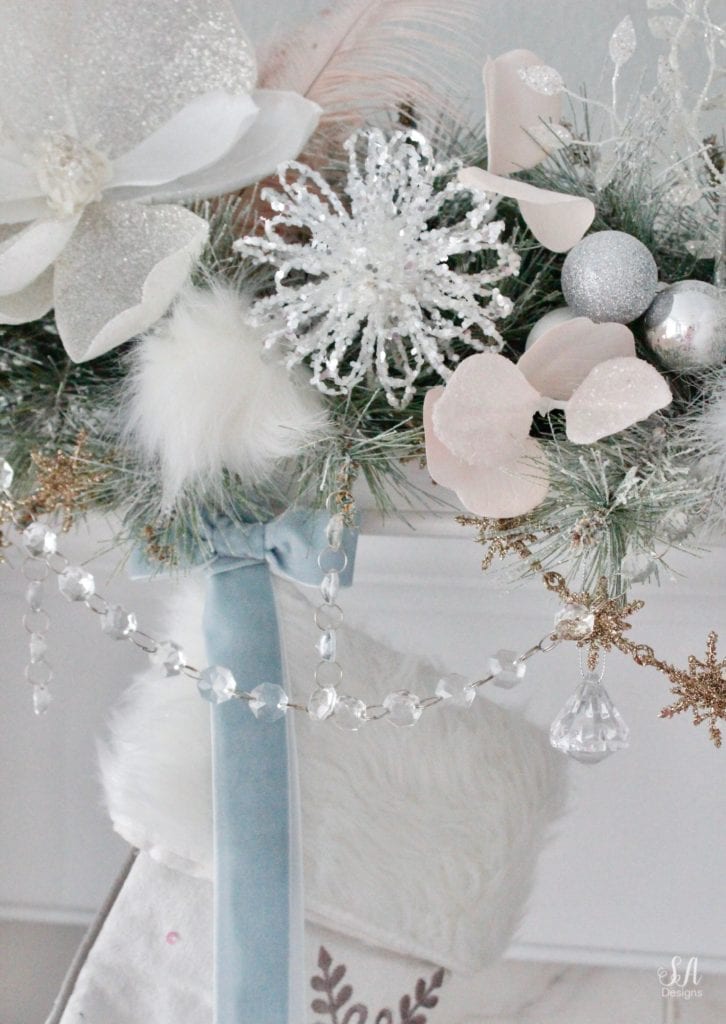 dreamy whimsical fantasy playful christmas mantel, faux fur stockings with snowflakes, christmas flocked garland with jewel rhinestone gold glitter pearl jewels garland, blush feather, faux fur pom poms, white glitter berry christmas stems, sparkly glitter christmas magnolia stems, dusty blue velvet ribbon, glitter snowflakes, joann fabric white swan figures, mercury glass candlesticks, cozy glam winter wonderland christmas, white fireplace marble tile