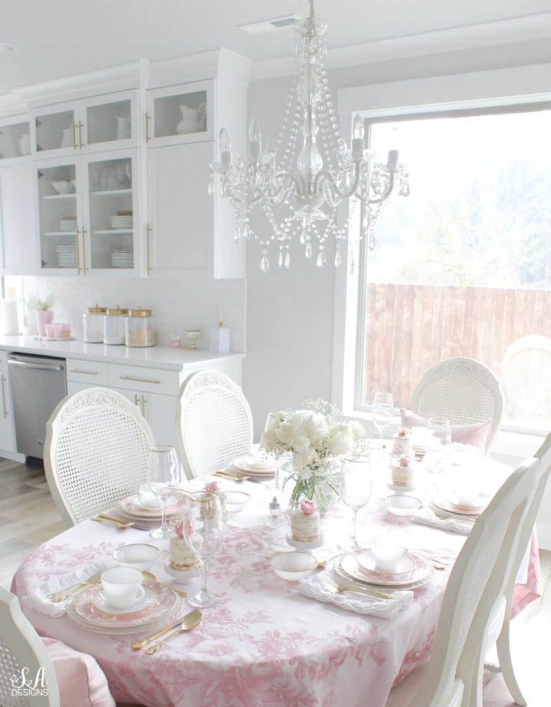 monique lhuillier pottery barn, pink floral tablecloth, pink floral plates, white kitchen design, vintage valentines day tablescape, valentines decor table