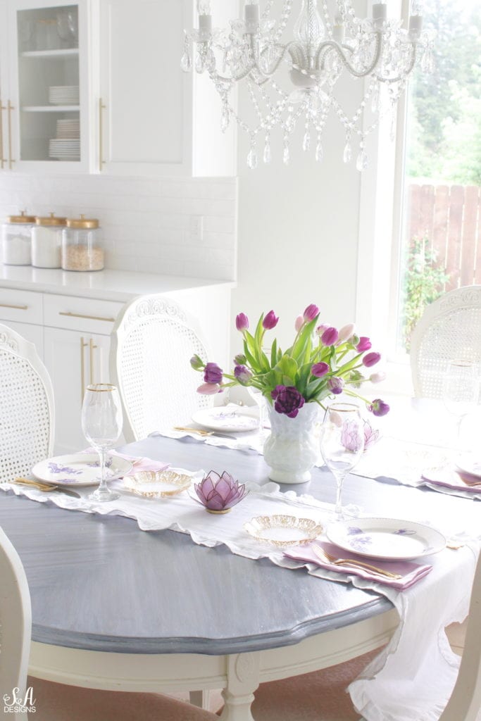 summer tablescape, spring tablescape, purple tablescape, purple tulips arrangement, purple lavender tulips, purple double peony tulips, double tulip peonies, antique french lavender transferware plates, paris france flea market find, gold flatware, purple orchid dinner napkins world market, gold rimmed crystal goblets, purple petal lotus capiz tea light holder world market, white ruffle linen table runners, crystorama clear crystal chandelier, anthropologie mauve lavender blouse top, white kitchen design, pacific northwest interior designer blogger fashion blogger summer adams designs, white milkglass vase