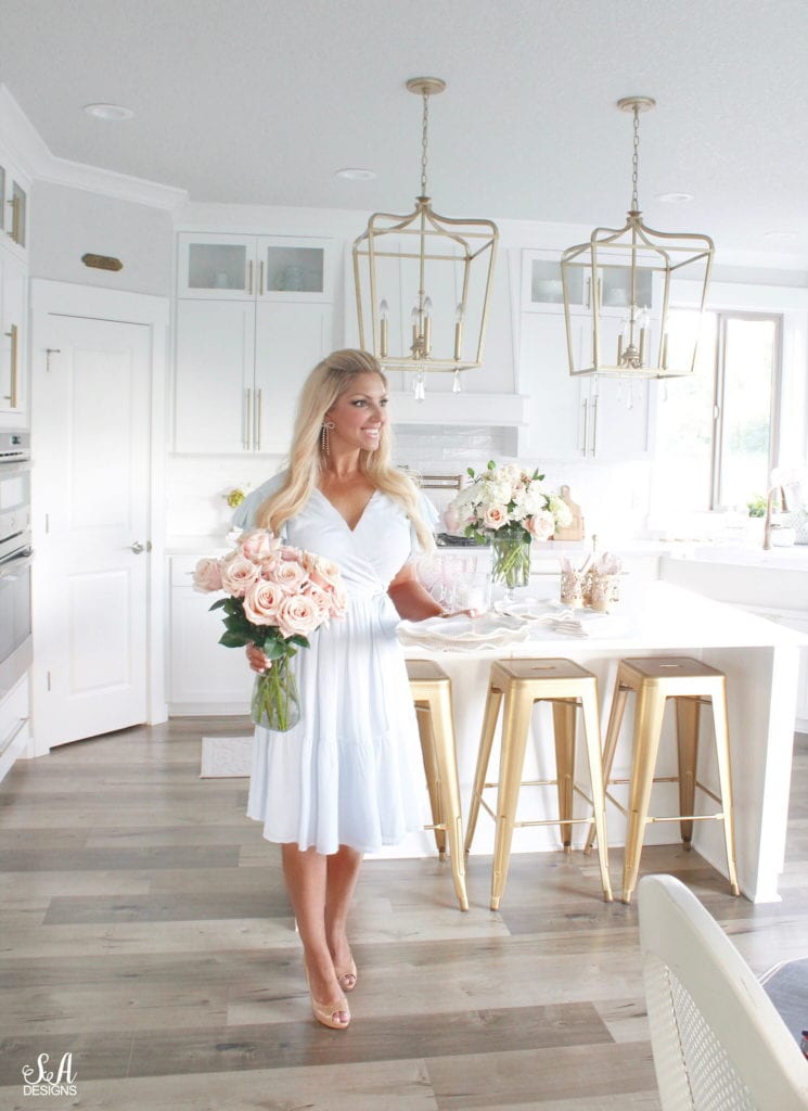 rachel parcell blue dress, summer entertaining dining, white classy elegant kitchen design, brass gold lighting, brass pendants, white quartz, gold industrial barstools, pink roses, setting the table, elegant interiors, summer adams interior designer blogger, pdx blogger pacific northwest blogger, entertaining blog