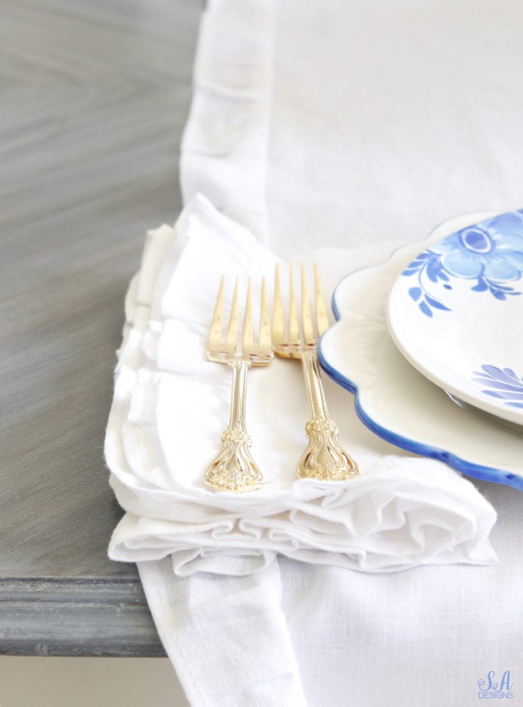 patriotic Tablescape, fourth of July table, red white and blue Tablescape table setting place setting, chinoiserie place setting, chinoiserie patriotic table, Aerin table place setting, Aerin plates Williams-Sonoma, scalloped plates, blue white plates, white ruffle dinner napkins, elegant gold flatware, red goblets, white ruffle table runners, white kitchen