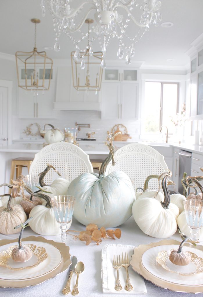 classy fall table, glam fall table, glam fall tablescape, elegant fall tablescape, white and gold fall table, gilded fall table, spa blue fall table, hot skwash velvet pumpkins, patina vie Aquarius goblets, ruffled tablecloth, ruffled ivory dinner napkins, gold flatware, gold-rimmed plates, gold flower butter plate dessert plates, vintage milk glass plates gold rim, gold chargers, pier1 gold eucalyptus stems, pier1 gold money glitter stems, white and gold fall kitchen decor, white velvet pumpkins, bellacor minka lavery pendants, white kitchen design, velvet pumpkins with Swarovski crystals, French country dining set, coastal kitchen, transitional kitchen, contemporary white elegant kitchen