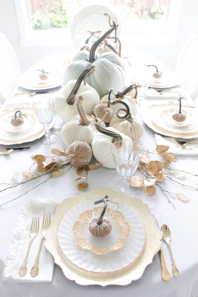 classy fall table, glam fall table, glam fall tablescape, elegant fall tablescape, white and gold fall table, gilded fall table, spa blue fall table, hot skwash velvet pumpkins, patina vie Aquarius goblets, ruffled tablecloth, ruffled ivory dinner napkins, gold flatware, gold-rimmed plates, gold flower butter plate dessert plates, vintage milk glass plates gold rim, gold chargers, pier1 gold eucalyptus stems, pier1 gold money glitter stems, white and gold fall kitchen decor, white velvet pumpkins, bellacor minka lavery pendants, white kitchen design, velvet pumpkins with Swarovski crystals, French country dining set, coastal kitchen, transitional kitchen, contemporary white elegant kitchen