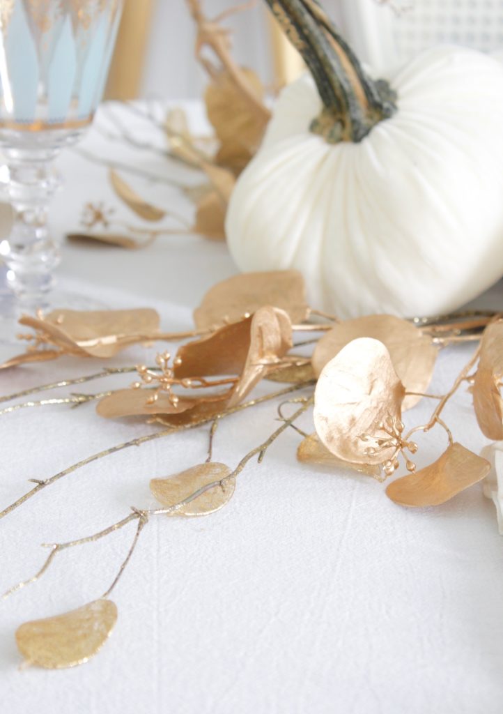 classy fall table, glam fall table, glam fall tablescape, elegant fall tablescape, white and gold fall table, gilded fall table, spa blue fall table, hot skwash velvet pumpkins, patina vie Aquarius goblets, ruffled tablecloth, ruffled ivory dinner napkins, gold flatware, gold-rimmed plates, gold flower butter plate dessert plates, vintage milk glass plates gold rim, gold chargers, pier1 gold eucalyptus stems, pier1 gold money glitter stems, white and gold fall kitchen decor, white velvet pumpkins, bellacor minka lavery pendants, white kitchen design, velvet pumpkins with Swarovski crystals, French country dining set, coastal kitchen, transitional kitchen, contemporary white elegant kitchen