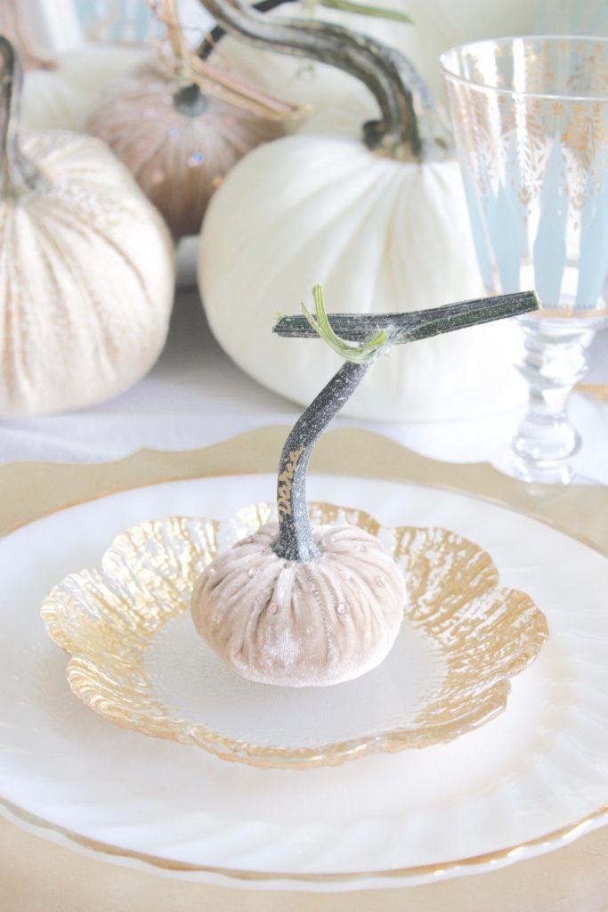 classy fall table, glam fall table, glam fall tablescape, elegant fall tablescape, white and gold fall table, gilded fall table, spa blue fall table, hot skwash velvet pumpkins, patina vie Aquarius goblets, ruffled tablecloth, ruffled ivory dinner napkins, gold flatware, gold-rimmed plates, gold flower butter plate dessert plates, vintage milk glass plates gold rim, gold chargers, pier1 gold eucalyptus stems, pier1 gold money glitter stems, white and gold fall kitchen decor, white velvet pumpkins, bellacor minka lavery pendants, white kitchen design, velvet pumpkins with Swarovski crystals, French country dining set, coastal kitchen, transitional kitchen, contemporary white elegant kitchen