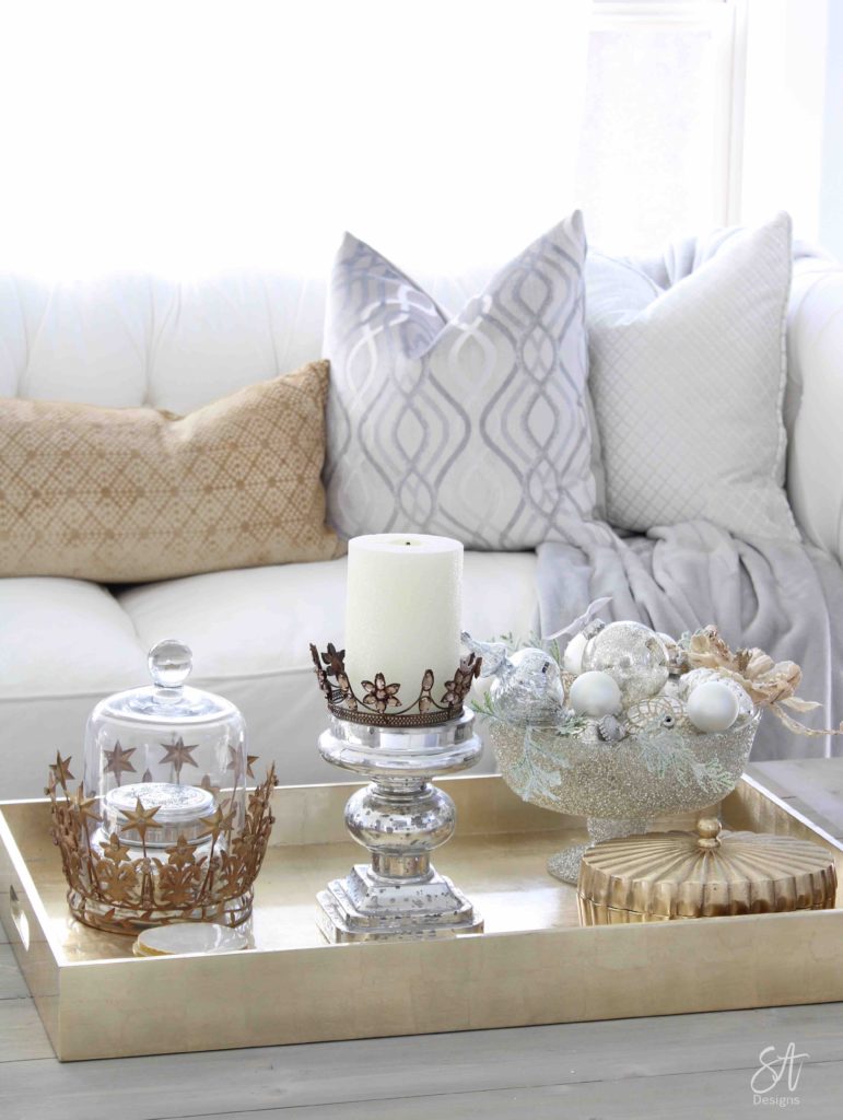 white and gold elegant glam Christmas decor, Christmas coffee table, ornaments in ZGallerie beaded pedestal bowl with ribbon, terrain Anthropologie Santos crowns, crowns on candlesticks, mercury glass candlesticks, Christmas coffee table, gold lacquer tray, restoration hardware baluster coffee table, grey and gold velvet pillows