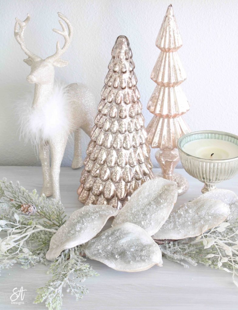 white Christmas tree, pink poinsettia Christmas ornaments, vintage pink glass ornaments, crown Christmas tree topper, romantic Christmas bedroom, blush pink mercury glass trees, glitter reindeer, blue pink velvet quilted bedding, blush pink fringe ottoman, pottery barn jewelry storage, Christmas bedroom decor ideas, master bedroom Christmas decorating ideas