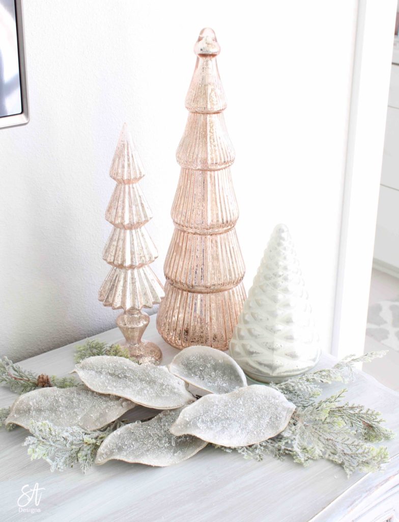 white Christmas tree, pink poinsettia Christmas ornaments, vintage pink glass ornaments, crown Christmas tree topper, romantic Christmas bedroom, blush pink mercury glass trees, glitter reindeer, blue pink velvet quilted bedding, blush pink fringe ottoman, pottery barn jewelry storage, Christmas bedroom decor ideas, master bedroom Christmas decorating ideas