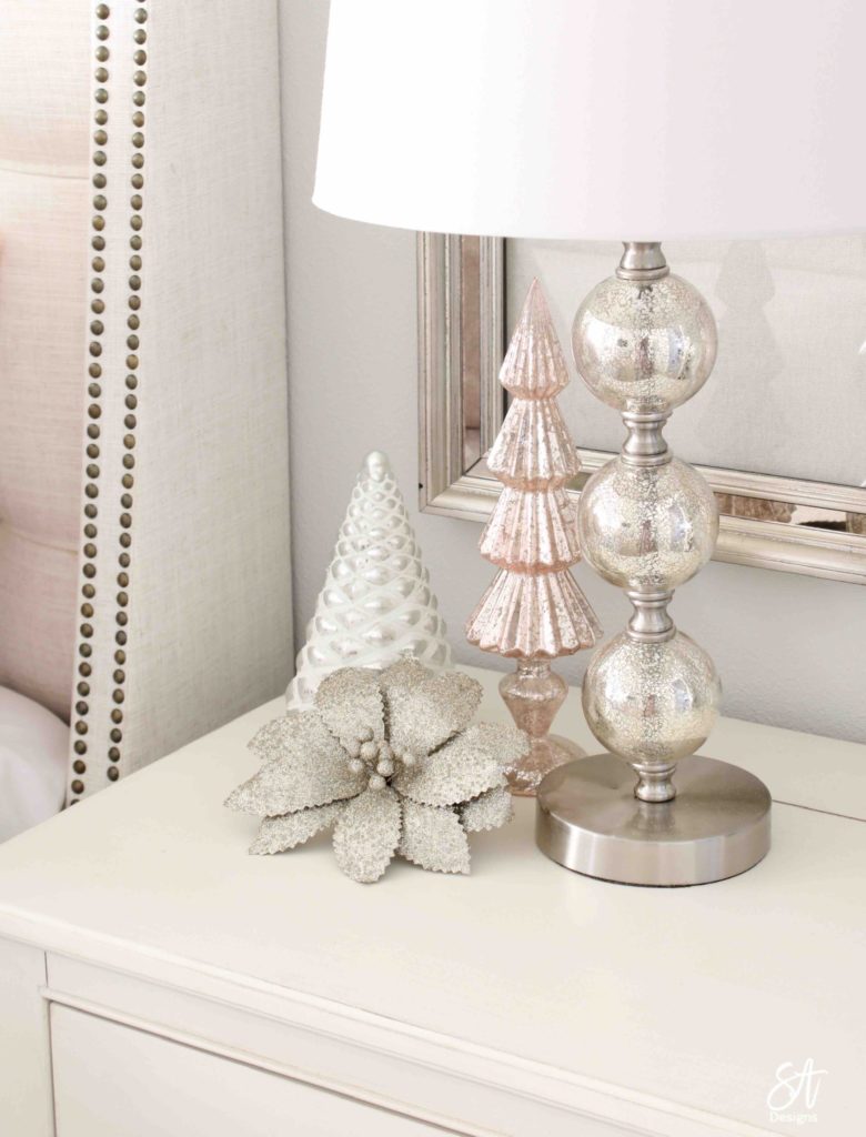 white Christmas tree, pink poinsettia Christmas ornaments, vintage pink glass ornaments, crown Christmas tree topper, romantic Christmas bedroom, blush pink mercury glass trees, glitter reindeer, blue pink velvet quilted bedding, blush pink fringe ottoman, pottery barn jewelry storage, Christmas bedroom decor ideas, master bedroom Christmas decorating ideas