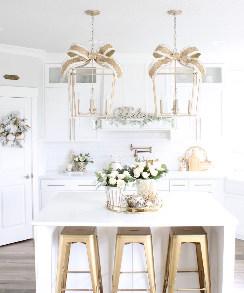 white and gold Christmas kitchen, glam Christmas kitchen, ribbon bows on kitchen pendants lighting, Christmas bows on kitchen lights, elegant Christmas kitchen, classy Christmas kitchen decorating, d. Stevens white and gold rhinestone Christmas ribbon, specialty white velvet gold rhinestone wired edge ribbon, gold barstools, Christmas floral arrangements, white and gold Christmas wreath, white kitchen design, white Christmas decor, white and gold Christmas kitchen decor