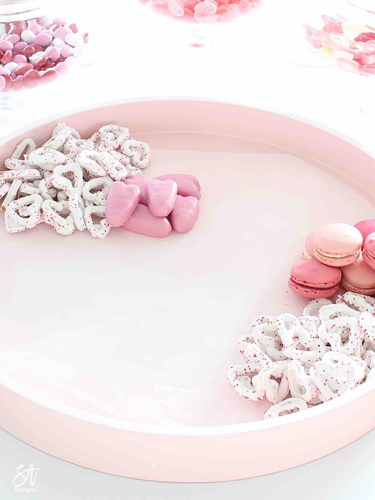 Valentine's Day dessert board, Valentine's Day charcuterie dessert board, dessert tray, dessert board, dessert candy board, dessert charcuterie board tray, pink circle round tray, pink candy dessert cookie tray, white kitchen entertaining, white kitchen island, white and gold decor, white and gold kitchen design, elegant glam white kitchen, white kitchen island, gold brass pendant kitchen lighting, Lindt chocolates, ghiradelli chocolates, Valentine's Day chocolate candies, dessert ideas, the prettiest dessert board ever, blogger dessert board, candy board tray, valentine's fashion, top knot pearl headband, voluspa candle, French pink Valentine's Day macarons, Reese's peanut butter hearts, Valentine's Day heart and lips cookies, Whole Foods market valentine's cookies