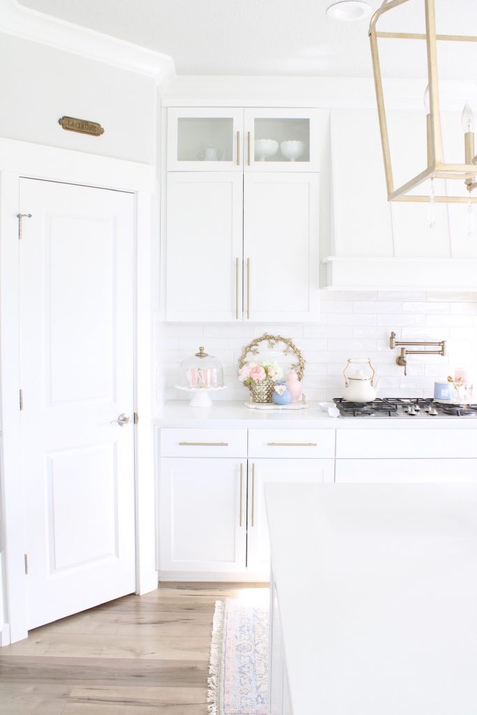 pink and blue spring kitchen decor, white kitchen design, white and gold kitchen, voluspa large 5 wick candle, voluspa macaron candles, white hood, white and gold kitchen, kitchen goals, Caitlin Wilson blue bread cutting board French blue, blogger kitchen inspiration