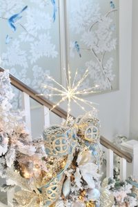 white flocked prelit christmas garland for banister staircase, trinity scroll velvet ribbon spa blue wired edge christmas ribbon, flocked christmas tree, glamorous christmas tree decorating tips, how to create a glam christmas tree, christmas decorating Tips, how to decorate a Christmas tree, elegant chic christmas tree entry, dramatic christmas entry, christmas tree stylist, blogger christmas tree, pottery barn mercury glass christmas trees