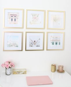 white and gold office, blush office, glam office, etagere gold shelves, Maltese dog, nesting boxes, home office, feminine office, diptyque candles used a flower vase, upcycled diptyque candle holder, white ginger jar pink cherry blossom stems, white matted gold frame set, office accessories, desk accessories, leopard slippers, white and gold leather office chair with wheels, pink pom pom throw blanket, blush tassel tote, gold office shelves, office shelving, how to decorate shelves, blogger office