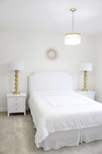 gold sunburst wall mirror, large gold lamps, serene spa blue guest bedroom, walmart home, white nightstands, white modern headboard, spa blue quilt bedding