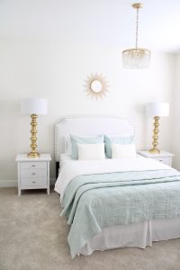 gold sunburst wall mirror, large gold lamps, serene spa blue guest bedroom, walmart home, white nightstands, white modern headboard, spa blue quilt bedding
