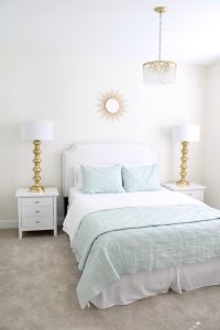gold sunburst wall mirror, large gold lamps, serene spa blue guest bedroom, walmart home, white nightstands, white modern headboard, spa blue quilt bedding