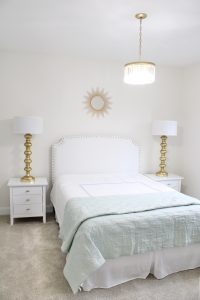gold sunburst wall mirror, large gold lamps, serene spa blue guest bedroom, walmart home, white nightstands, white modern headboard, spa blue quilt bedding