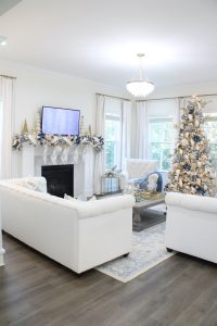 white and gold decor, glam christmas, white walls, ginger jars, classy christmas, christmas blogger tour, white sofas, custom pillow covers, flocked christmas tree, flocked garland christmas mantel